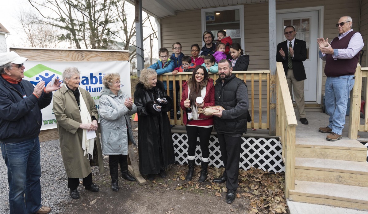 Actors from "It's a Wonderful Life" present "Bread, Salt & Wine" to Alicia and Jason Carnicelli and their nine children as part of a housewarming ceremony is association with Habitat for Humanity.  Menzo Case, President of the Board of Habitat for Humanity Seneca County, and Lou Ferrara, Construction Chair, can be seen to the right.  Photo by Henry Law